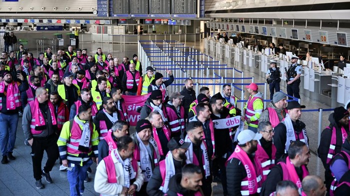 Pekerja Bandara di Jerman Mogok Kerja, Protes soal Upah Workers hold a banner as they demonstrate during a 24-hour strike at the Frankfurt Airport called by the German trade union Verdi over a wage dispute in Frankfurt, Germany March 10, 2025. The banner reads,