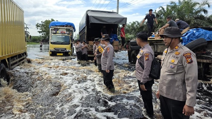 Petugas saat pengaturan lalulintas di lokasi banjir. (Dok Polsek Pangkalan Kerinci)