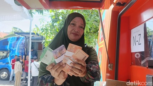 Salah satu warga menunjukkan uang pecahan baru yang telah ditukarkan di layanan kas keliling milik Bank Indonesia (BI) Provinsi Bali di Masjid IKMS Bali, Denpasar, Senin (10/3/2025). (Foto: Ni Made Lastri Karsiani Putri/detikBali)