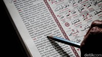 Seorang warga membaca terjemah Al-quran.  
