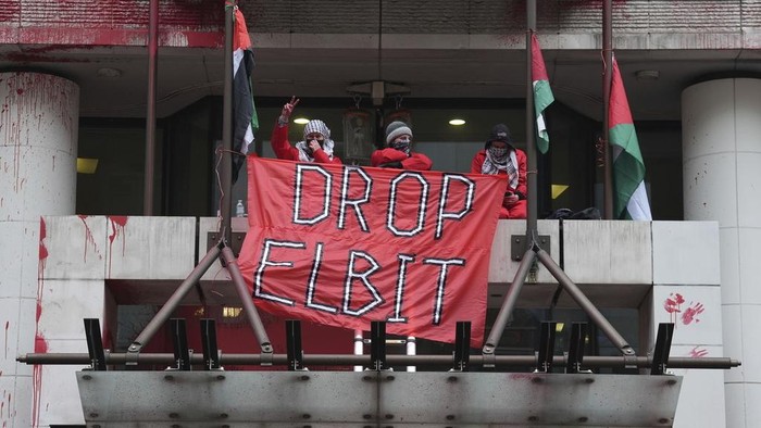 Members of Palestine Action occupy and deface the entrance of a branch of Allianz Insurance commercial offices in protest over its links to Israeli Arms company, Elbit Systems, in London, Monday, March 10, 2025. (Lucy North/PA via AP)