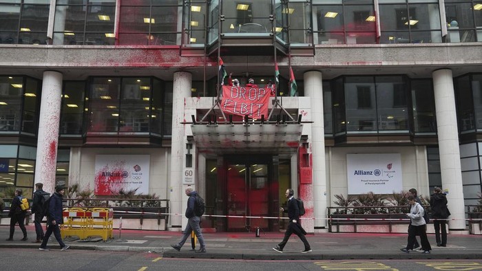Kantor Asuransi di Jerman Diserang Aktivis Pro Palestina Members of Palestine Action occupy and deface the entrance of a branch of Allianz Insurance commercial offices in protest over its links to Israeli Arms company, Elbit Systems, in London, Monday, March 10, 2025. (Lucy North/PA via AP)