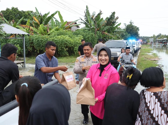 Kapolres Grobogan, AKBP Ike Yulianto, dan Ketua Bhayangkari Cabang Grobogan, Ratih Ike Yulianto, bagi-bagi takjil dan nasi kotak ke warga terdampak banjir, Selasa (11/3/2025).