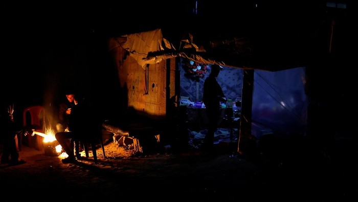 A Palestinian man rests in a makeshift shop during a power cut, in Rafah in the southern Gaza Strip, March 9, 2025. REUTERS/Hatem Khaled