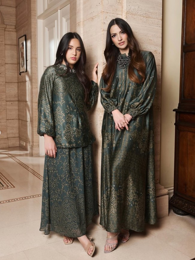 Look pertama, Nia dan putrinya, Mikhayla, tampil dalam balutan busana berwarna hijau dengan motif warna keemasan. Nia tampil dengan one set dress panjang, sementara Mikhayla mengenakan dress 2 piece. Foto: Instagram/@ramadhaniabakrie/@geulis.id