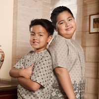 Kedua anak laki-laki Ardi dan Nia, Mainaka dan Magika, tampak mengenakan kemeja koko bermotif warna coklat muda. Kemeja tersebut dipadukan dengan celana panjang berwarna krem. Foto: Instagram/@ramadhaniabakrie/@geulis.id