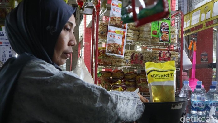 Pedagang menimbang minyakita yang tidak sesuai dengan label di Pasar Rogowangsan Pati, Selasa (11/3/2025).