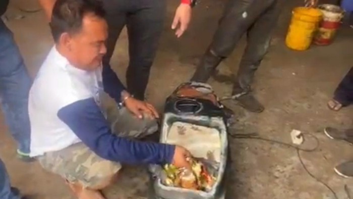 Pelaku saat menunjukkan sabu yang diselundupkan di tangki mobil. (Foto: Dok. Polda Sumut).
