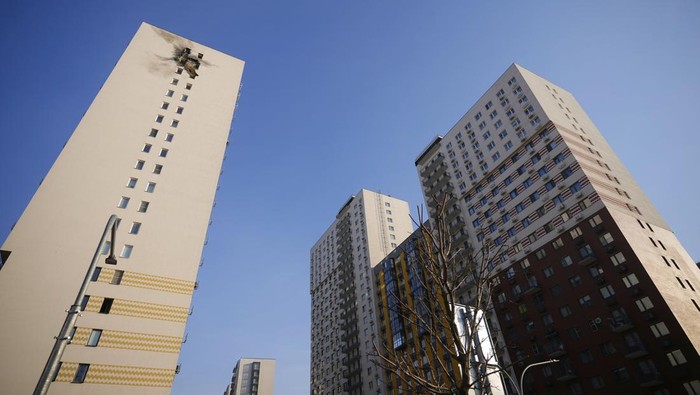 This photo shows an apartment building, top, where the downed Ukrainian drone fell at an area in Sapronovo village outside Moscow, Russia, on Tuesday, March 11, 2025. (AP Photo)