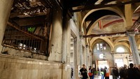 Warga Palestina memeriksa bagian dalam masjid yang menghitam dan rusak yang merupakan salah satu landmark kota tua Nablus, mereka membersihkan jendela dan berkumpul untuk salat di dalamnya.