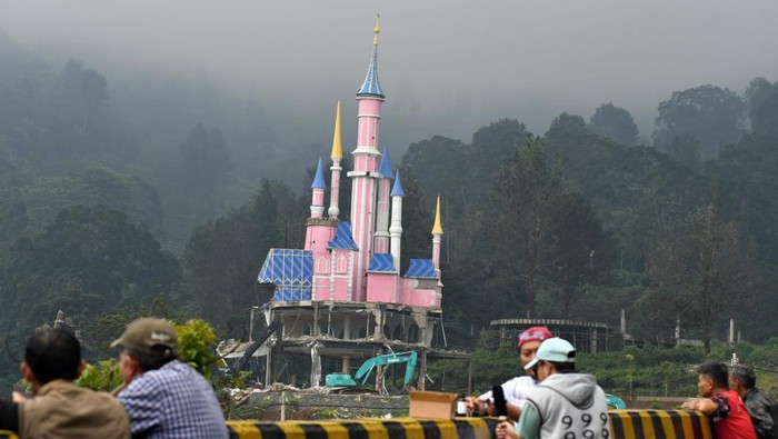Warga menyaksikan pembongkaran bangunan tempat wisata di Hibisc Fantasy Puncak, Cisarua, Kabupaten Bogor, Jawa Barat, Senin (10/3/2025). Progres pembongkaran bangunan tempat wisata milik PT Jaswita Lestari Jaya tersebut baru mencapai 35 persen pada Minggu (9/3/2025) dan ditargetkan selesai pada 27 Maret mendatang. ANTARA FOTO/Arif Firmansyah/YU
