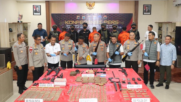 Polisi saat mamerkan senjata api dan amunisi yang hendak disuplai ke KKB.
