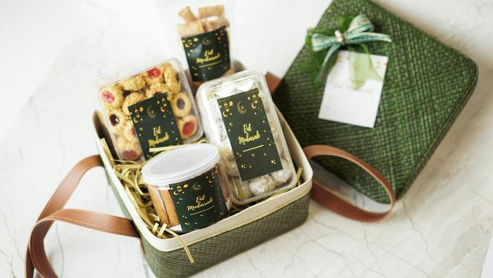 Ramadhan gift. Hampers moslem theme for celebrete the holy, bake snack, nastar, bakery, cookies, pudiing, chococips, roll cake, castangel.with greeting card and green accessories on white background