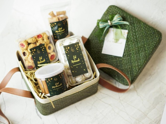 Ramadhan gift. Hampers moslem theme for celebrete the holy, bake snack, nastar, bakery, cookies, pudiing, chococips, roll cake, castangel.with greeting card and green accessories on white background