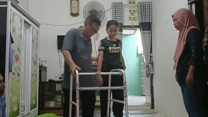 Kondisi Amel, bersama Ibu dan Agus ketika belajar berjalan di rumahnya.