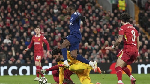 PSGs Ousmane Dembele jumps over Liverpools goalkeeper Alisson to score during the Champions League round of 16 second leg soccer match between Liverpool and Paris Saint-Germain at Anfield in Liverpool, England, Tuesday, March 11, 2025. (AP Photo/Jon Super)