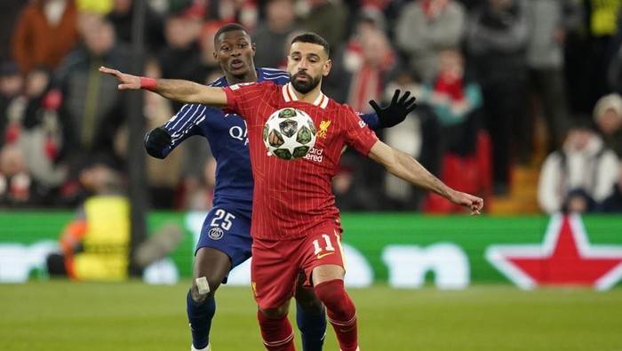 Liverpools Mohamed Salah shields the ball from PSGs Nuno Mendes during the Champions League round of 16 second leg soccer match between Liverpool and Paris Saint-Germain at Anfield in Liverpool, England, Tuesday, March 11, 2025. (AP Photo/Dave Thompson)