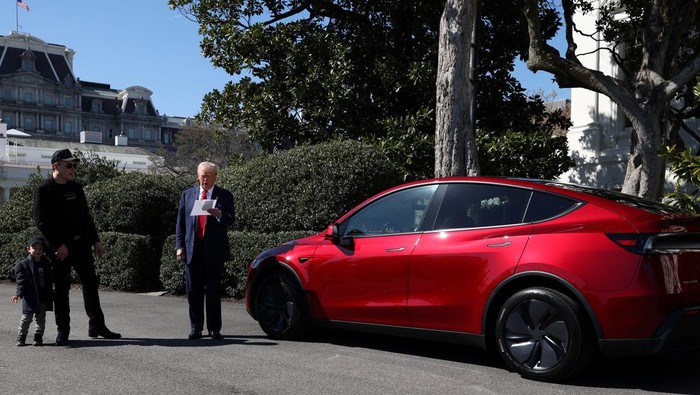 U.S. President Donald Trump talks to the media next to Tesla CEO Elon Musk, with Tesla cars in the background, at the White House in Washington, D.C., U.S., March 11, 2025. REUTERS/Kevin Lamarque