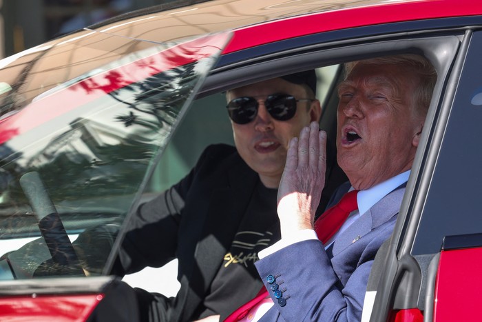 U.S. President Donald Trump talks to the media next to Tesla CEO Elon Musk, with Tesla cars in the background, at the White House in Washington, D.C., U.S., March 11, 2025. REUTERS/Kevin Lamarque