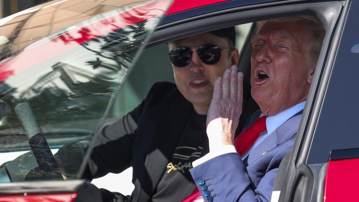 U.S. President Donald Trump talks to the media next to Tesla CEO Elon Musk, with Tesla cars in the background, at the White House in Washington, D.C., U.S., March 11, 2025. REUTERS/Kevin Lamarque