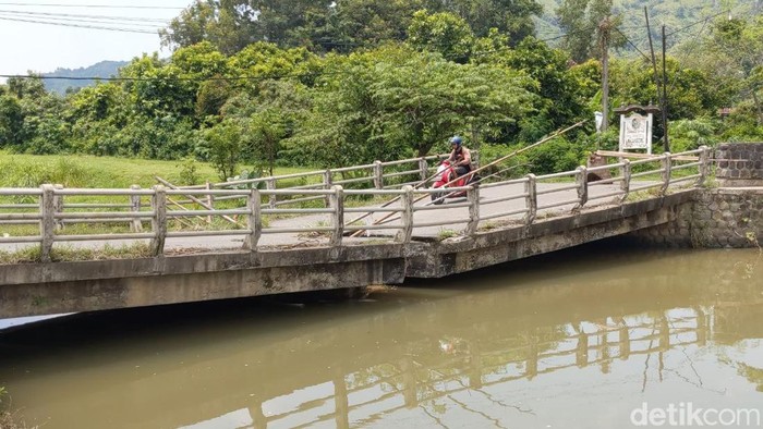 Pemotor nekat melintasi Jembatan Junjung Tulungagung yang rusak