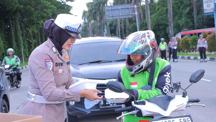 Polisi membagikan takjil kepada pengendara lalu lintas.