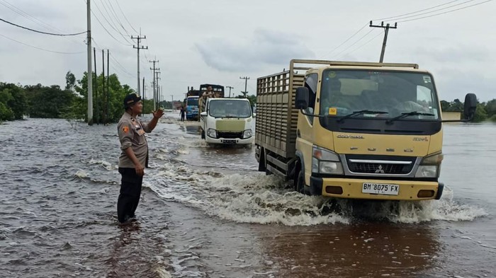 Polisi mengatur lalulintas di lokasi banjir