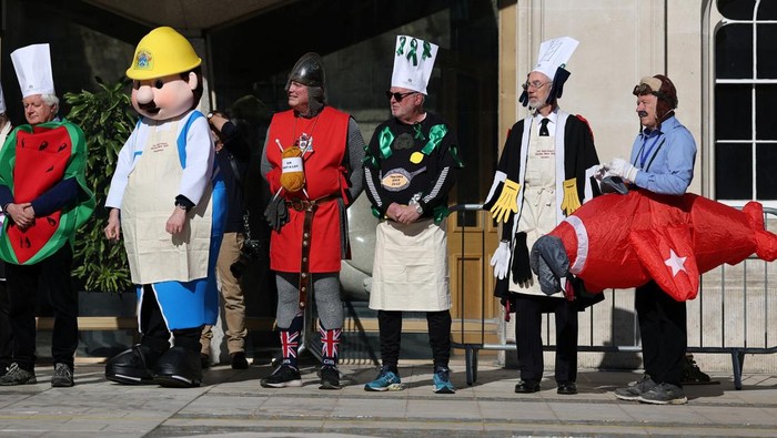 A competitor takes part in the annual Inter-Livery Pancake Races, on Shrove Tuesday, in Guildhall Yard, in London, Britain, March 4, 2025. REUTERS/Toby Melville      TPX IMAGES OF THE DAY