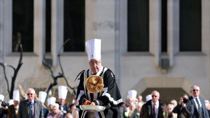 A competitor takes part in the annual Inter-Livery Pancake Races, on Shrove Tuesday, in Guildhall Yard, in London, Britain, March 4, 2025. REUTERS/Toby Melville TPX IMAGES OF THE DAY