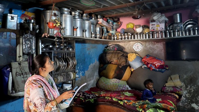 Painters apply liquid-applied membrane (LAM) coating that according to the authorities helps to bring down the temperature inside the shanties at a slum in Ahmedabad, India, January 30, 2025. REUTERS/Amit Dave