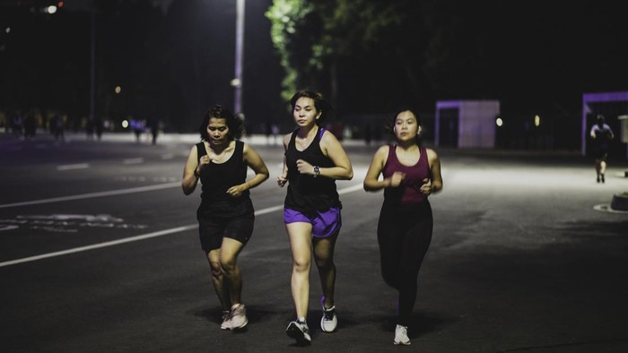 group asian female running after office hour in Jakarta Street,