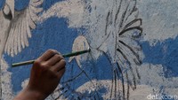 Tampak detail PPSU sedang melukis burung.