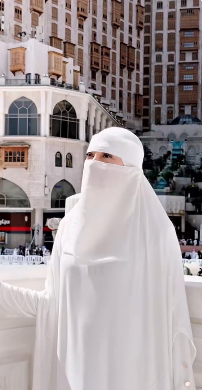 Wanita kelahiran 2 April 1992 ini mengenakan gamis dan cadar putih saat berjalan di sekitar Masjidil Haram. Ia merasa sangat berkesan ketika pertama kali berada di Tanah Suci. Foto: Dok. Instagram @celine_evangelista.
