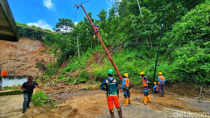 Petugas PLN sedang memperbaiki jaringan listrik di lokasi bencana Sukabumi.