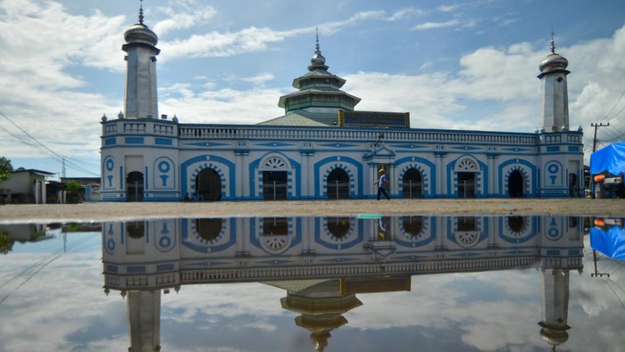 Warga melintas di depan Masjid Raya Ganting di Padang, Sumatera Barat, Kamis (13/3/2025). Masjid peninggalan abad ke-19 dibangun pada tahun 1805 itu arsitekturnya merepresentasikan akulturasi etnis-etnis yang ada di Padang dengan pengaruh neoklasik dari Eropa yang dominan pada bagian fasad. ANTARA FOTO/Iggoy el Fitra/Spt.