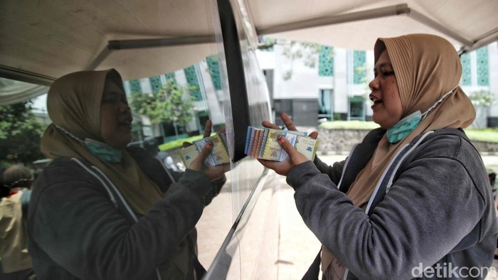 Sejumlah warga antre untuk mengambil uang pecahan untuk lebaran di mobil kas keliling milik Bank Indonesia di kawasan Jakarta Islamic Centre, Jakarta Utara,  Kamis (13/3/2025).