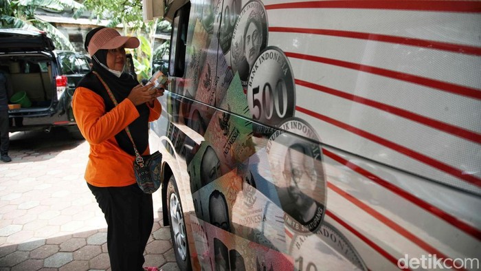 Sejumlah warga antre untuk mengambil uang pecahan untuk lebaran di mobil kas keliling milik Bank Indonesia di kawasan Jakarta Islamic Centre, Jakarta Utara,  Kamis (13/3/2025).