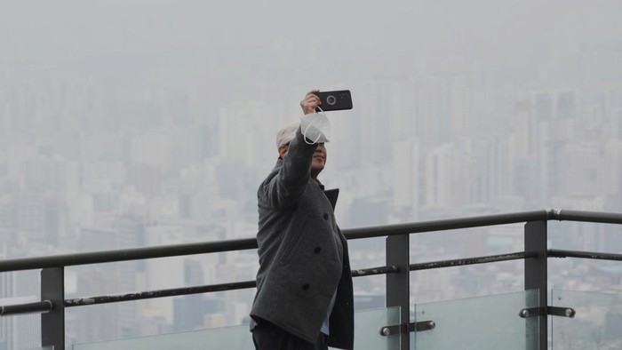 Seoul Terapkan Protokol Darurat Saat Diselimuti Polutan Debu Halus People are silhouetted as the cityscape is covered with a thick haze of fine dust particles at the National Museum of Korea in Seoul, South Korea, Wednesday, March 12, 2025. (AP Photo/Ahn Young-joon)