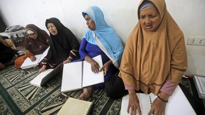 Suasana Pesantren Ramadan untuk Santri Lansia Disabilitas di Medan Visually impaired people read the Quran written in braille as they attend a Quran reading class during the holy fasting month of Ramadan in Medan, North Sumatra, Indonesia, Thursday, March 6, 2025. (AP Photo/Binsar Bakkara)