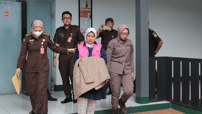 Tersangka WH mengenakan rompi merah muda usai ditetapkan tersangka kasus korupsi dana eks PNPM Desa Tinggarjaya, Kecamatan Jatilawang, Kabupaten Banyumas, Kamis (13/3/2025).