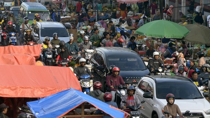 Sejumlah kendaraan tersendat akibat adanya pasar tumpah Pasir Gintung di Jalan Imam Bonjol, Tanjung Karang Pusat, Bandar Lampung, Lampung, Kamis (13/3/2025). Para pedagang pasar tumpah tersebut menggunakan setengah badan jalan yang juga akses jalur mudik sehingga menyebabkan arus lalu lintas tersendat dan mengakibatkan kemacetan pada jam sibuk. ANTARA FOTO/Ardiansyah/tom.