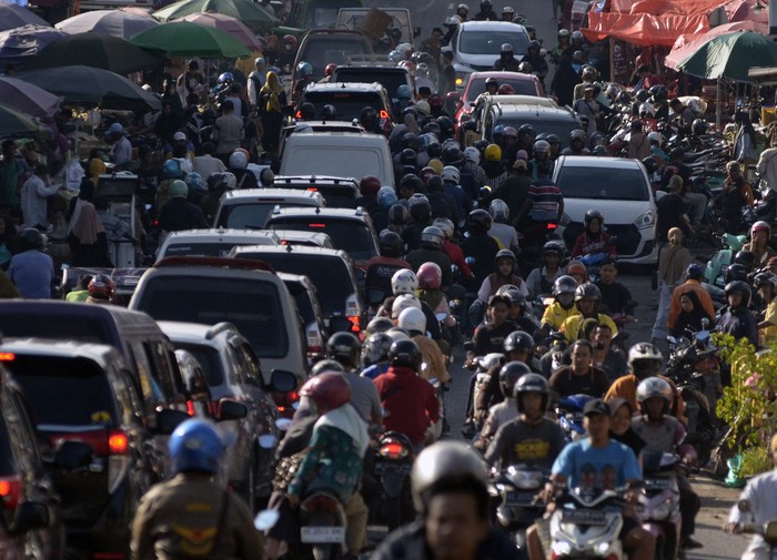 Sejumlah kendaraan tersendat akibat adanya pasar tumpah Pasir Gintung di Jalan Imam Bonjol, Tanjung Karang Pusat, Bandar Lampung, Lampung, Kamis (13/3/2025). Para pedagang pasar tumpah tersebut menggunakan setengah badan jalan yang juga akses jalur m