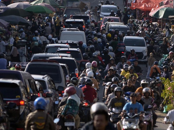 Sejumlah kendaraan tersendat akibat adanya pasar tumpah Pasir Gintung di Jalan Imam Bonjol, Tanjung Karang Pusat, Bandar Lampung, Lampung, Kamis (13/3/2025). Para pedagang pasar tumpah tersebut menggunakan setengah badan jalan yang juga akses jalur mudik sehingga menyebabkan arus lalu lintas tersendat dan mengakibatkan kemacetan pada jam sibuk. ANTARA FOTO/Ardiansyah/tom.