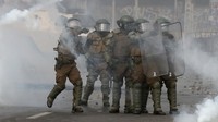 Polisi mencoba membubarkan massa yang semakin anarkis. 