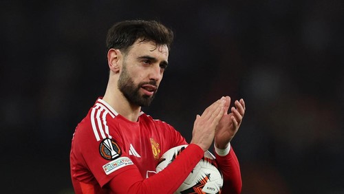 Soccer Football - Europa League - Round of 16 - Second Leg - Manchester United v Real Sociedad - Old Trafford, Manchester, Britain - March 13, 2025  Manchester Uniteds Bruno Fernandes celebrates with the match ball after the match after scoring a hat-trick REUTERS/Phil Noble