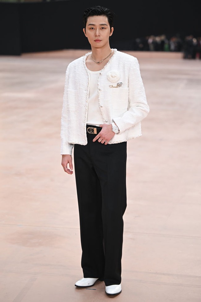 Park Seo Joon membuat penggemar pangling saat menghadiri Chanel Womenswear Fall/Winter 2025-2026 show. Bintang drama Korea Gyeongseong Creature itu memakai busana wanita Chanel berupa tweed jacket dengan aksen bunga berwarna putih. Penampilannya dilengkapi dengan jam tangan serasi, celana hitam, dan sepatu putih. Foto: dok. Getty Images