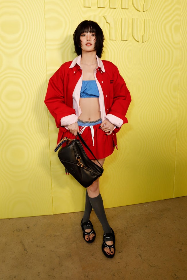 Personel grup KPop (G)I-DLE asal Thailand, Minnie tampil edgy dengan paduan balloon crop top biru di balik jaket dan mini skirt merah. Alih-alih memakai heels maupun boots, Minnie memakai sendal hitam dengan kaos kaki abu-abu. Foto: dok. Getty Images