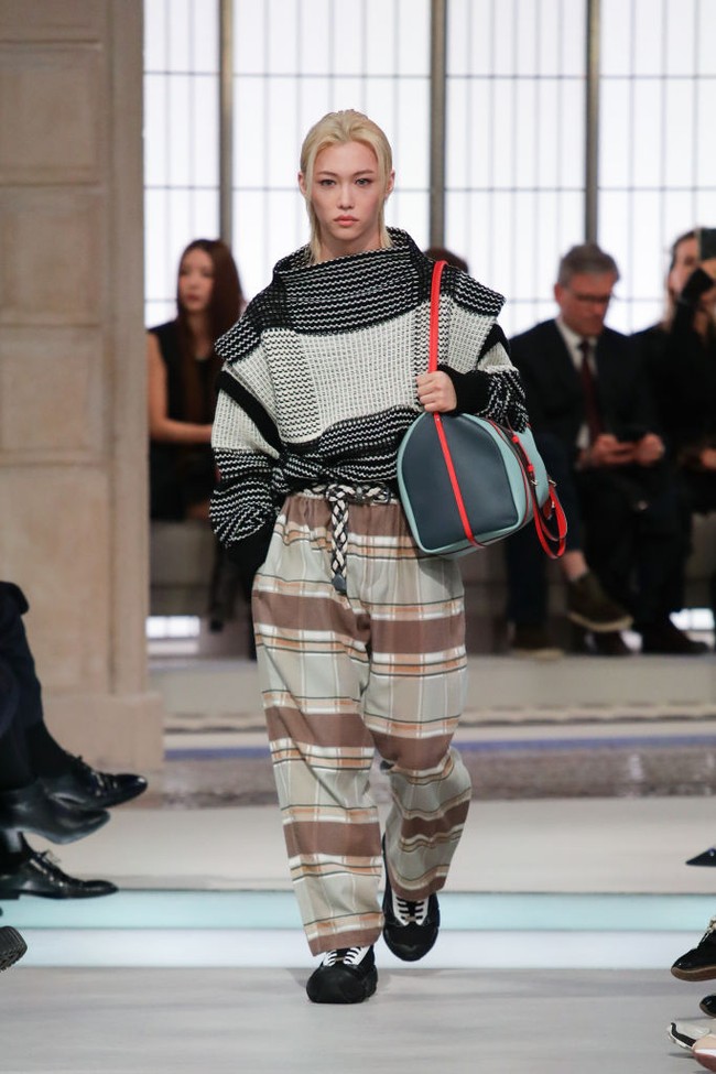 Felix Stray Kids, menjadi satu-satunya artis Korea yang tampil sebagai model di runway Paris Fashion Week 2025. Dikenal dengan gaya androgini, Felix memperagakan koleksi busana wanita Louis Vuitton memakai stripes sweater berwarna monokrom, checkered pants coklat, dan menyandang sachel bag bernuansa biru-oranye. Foto: dok. Getty Images