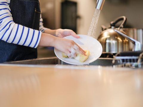 Waitress washing dish in the kitchen of restaurant