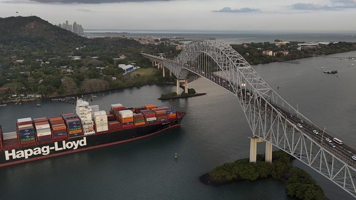 A cargo ship sails under Las Americas bridge through the Panama Canal, in Panama City, Thursday, March 13, 2025. (AP Photo/Matias Delacroix)